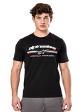 Alpinestars Prevail CSF Tee, Black Short Sleeve T-Shirt worn by a model, featuring white branding with a tri-color stripe and "PREMIUM RACEWEAR" graphic, casual motorsport streetwear