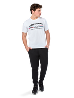 Alpinestars Prevail CSF Tee, Short Sleeve T-Shirt, White, featuring a front paddock-style tri-color stripe logo with Alpinestars branding, worn by a model with black joggers and black sneakers, casual motorsport streetwear