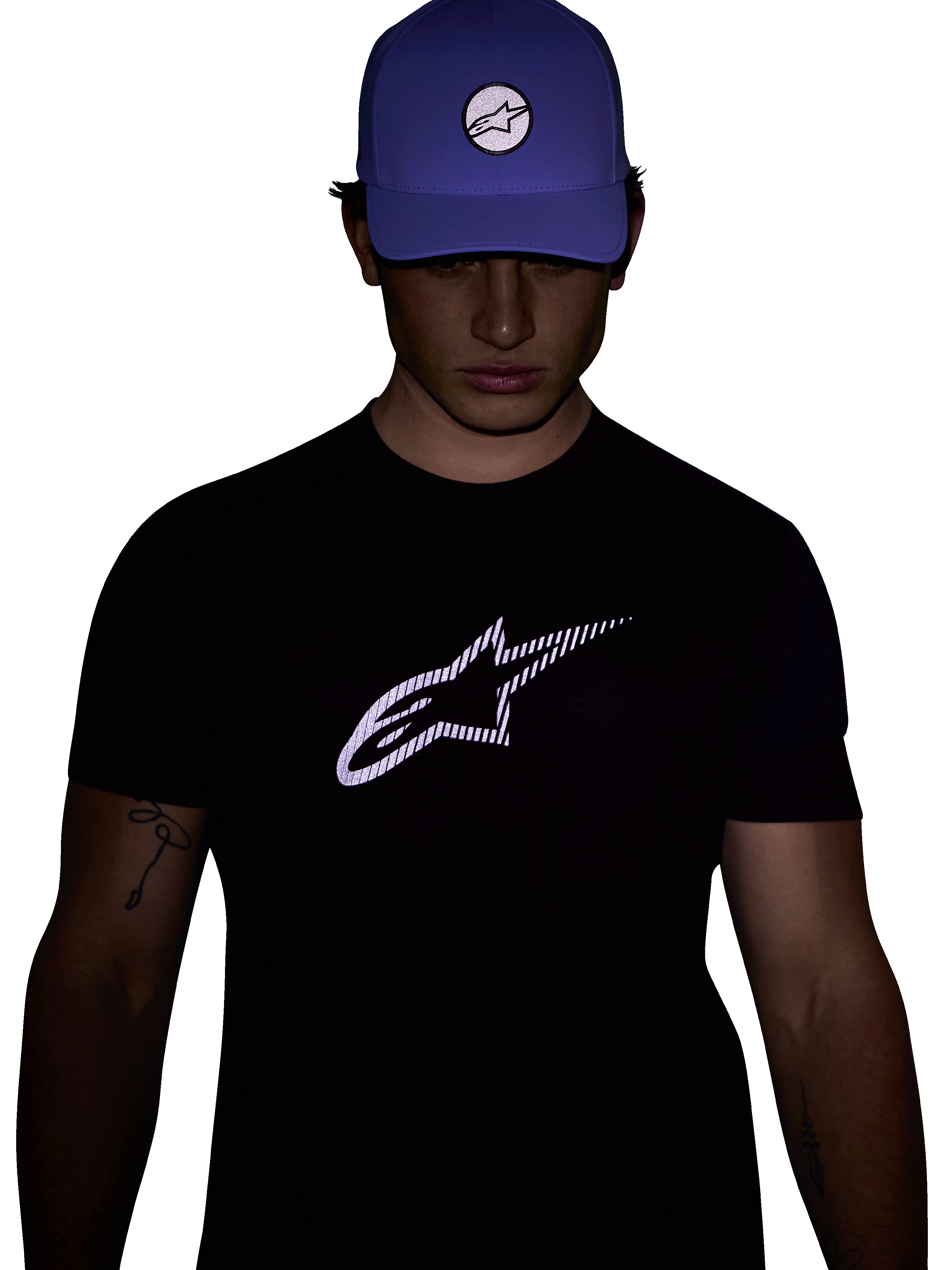 Alpinestars Exemption Performance Tee, Short Sleeve T-Shirt, Black, Featuring a large white reflective Alpinestars logo on the chest, worn with a blue cap, designed for visibility and performance sportswear