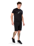 Alpinestars Exemption Performance Tee, Short Sleeve, Black, White Reflective Logo on Chest, worn with matching black shorts and sneakers, casual performance sportswear