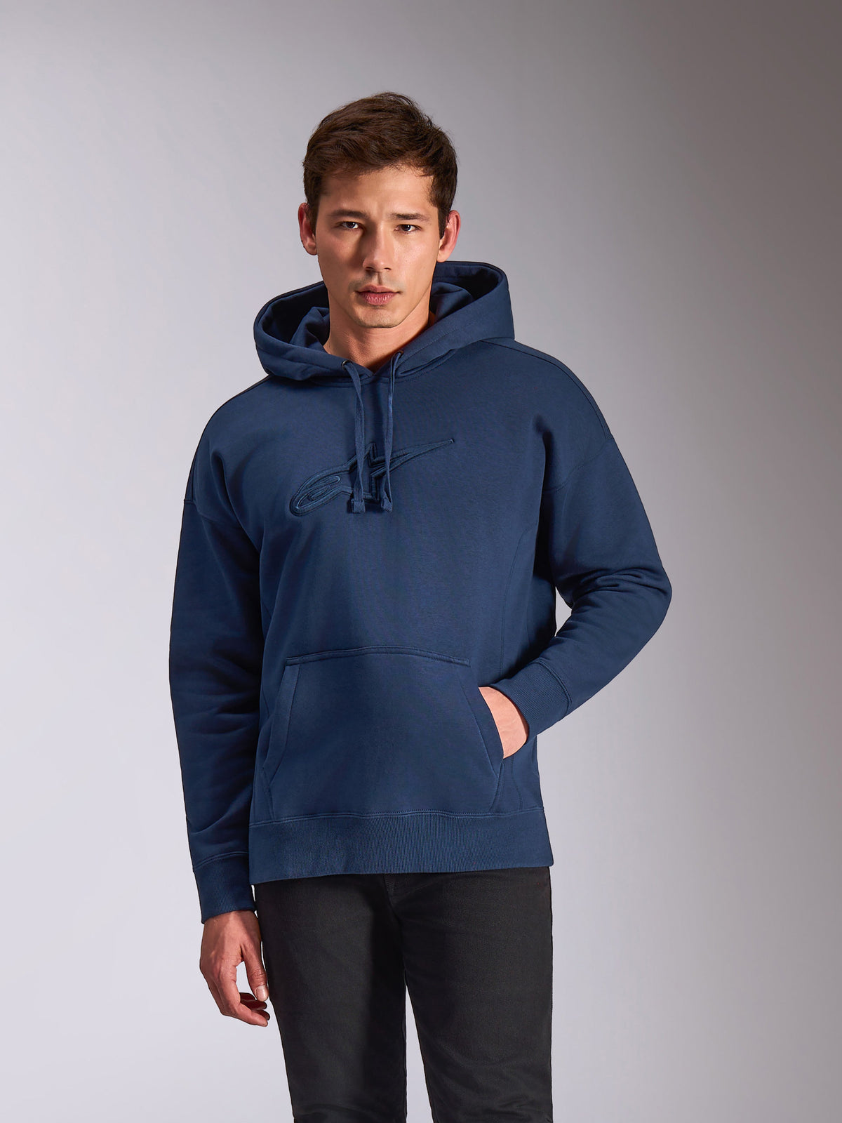 Alpinestars Emergent Oversized Hoodie, navy blue fleece pullover, tonal 3D embroidered Astars logo on the chest, relaxed oversized fit with kangaroo pocket and drawstring hood, casual motorsport-inspired streetwear