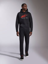 Alpinestars Pulse Hoodie, black casual streetwear hoodie, red and gray Astars combo logo with speed line fade on chest, drawstring hood, front pouch pocket, long sleeves, paired with black pants and sneakers, motorsport-inspired design