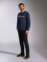 Alpinestars Mandatory CSF Tee, Long Sleeve T-Shirt, Navy, featuring front white Astars logo and yellow Alpinestars branding, Astars circle logo on sleeve, worn by a model with black pants and black sneakers for a casual lifestyle look