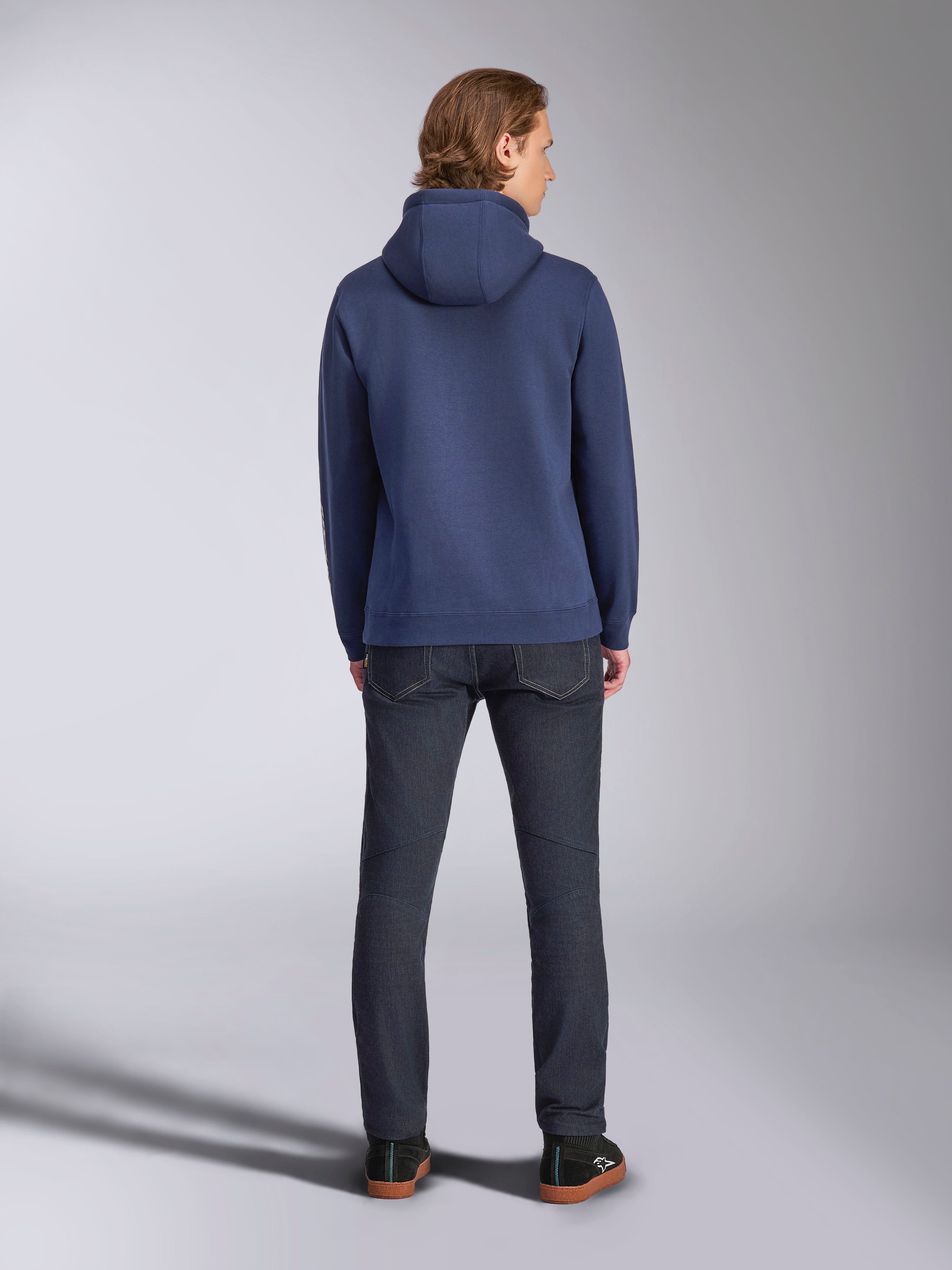 Alpinestars Harken Hoodie, Navy Blue, Rear View, Pullover Fleece Hoodie, Casual Sportswear, worn with dark denim jeans, showing the hood and ribbed hem