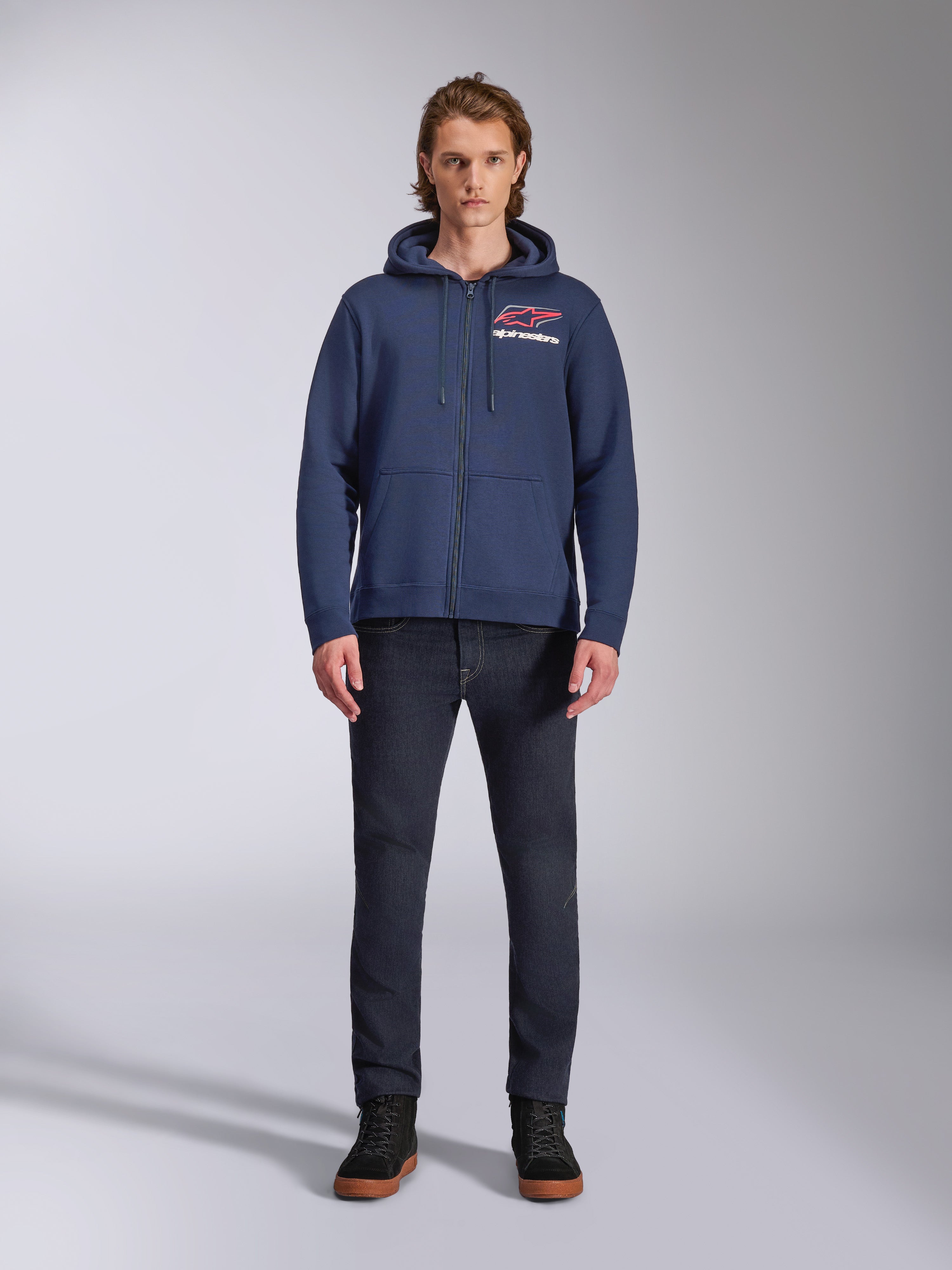 Alpinestars Formulation Hoodie, Navy Blue zip-up fleece hoodie, worn by male model with dark blue jeans, featuring red and white chest logo, mesh-lined hood with drawcords, casual motorsport streetwear