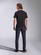 Alpinestars Entitled CSF Tee, Short Sleeve T-Shirt, Black, back view of a male model wearing the shirt with dark blue denim jeans, featuring a small white and green logo on the left sleeve, casual motorsport-inspired streetwear