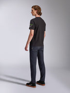 Alpinestars Entitled CSF Tee, Short Sleeve T-Shirt, Black, back-side profile of model wearing the tee with green and white sleeve logos, paired with dark denim and black sneakers, casual motorsport streetwear