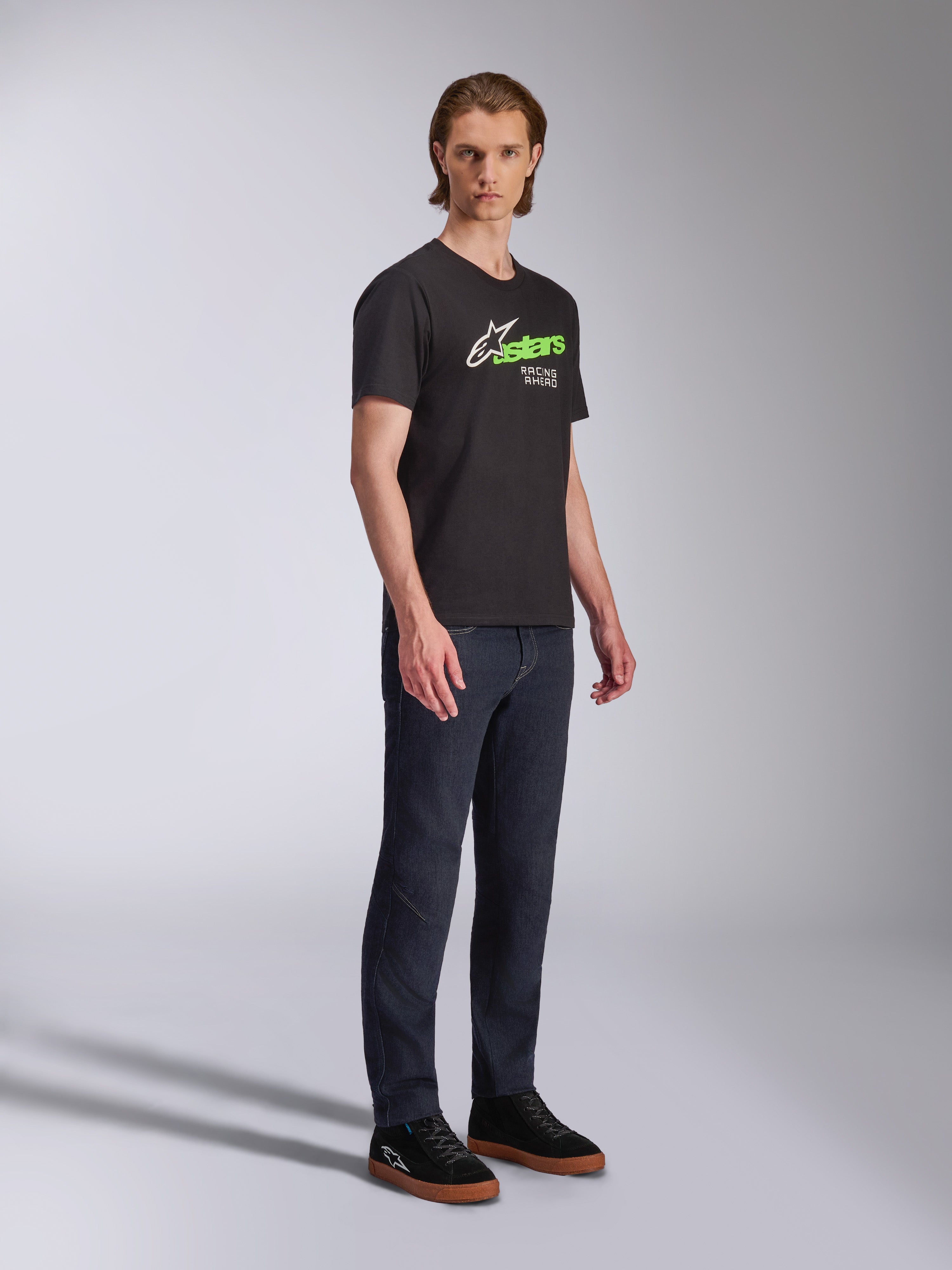 Alpinestars Entitled CSF Tee, Short Sleeve T-Shirt, Black, White and Green graphic with 'Racing Ahead' text, worn with dark jeans and black sneakers, Casual Motorsport Streetwear