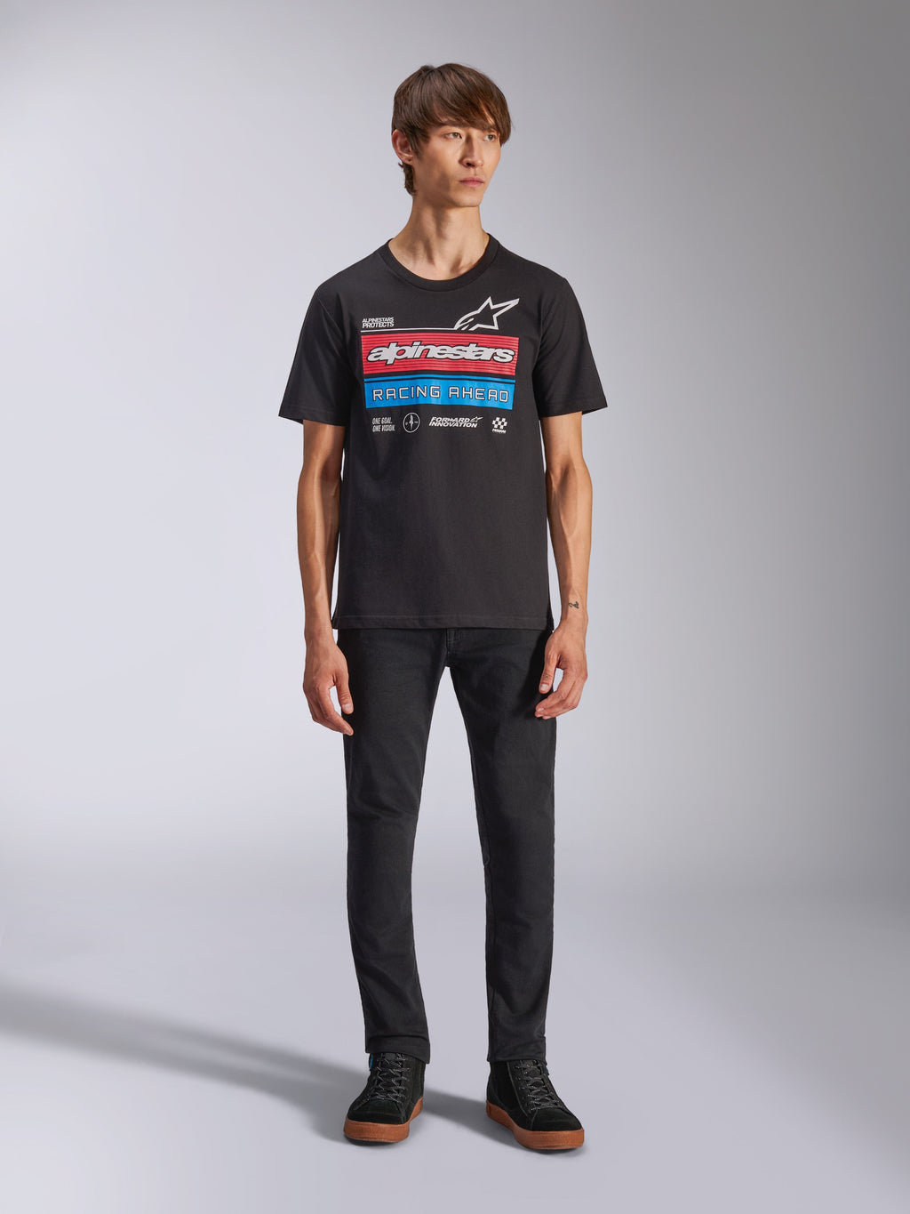 Alpinestars Harken CSF Tee, Short Sleeve T-Shirt, Black, featuring red and blue race-inspired front graphic with Alpinestars logo and 'Racing Ahead' text, worn by model with black pants, casual motorsport streetwear
