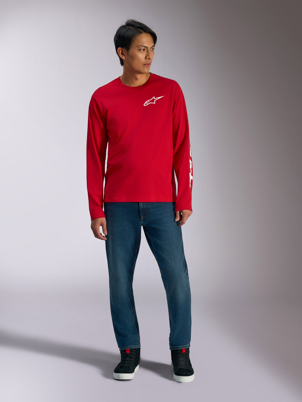 Alpinestars Trackside CSF Tee, Long Sleeve T-Shirt, Red with White Alpinestars Logo, lifestyle shot worn with blue jeans and black sneakers, casual motorsport-inspired sportswear
