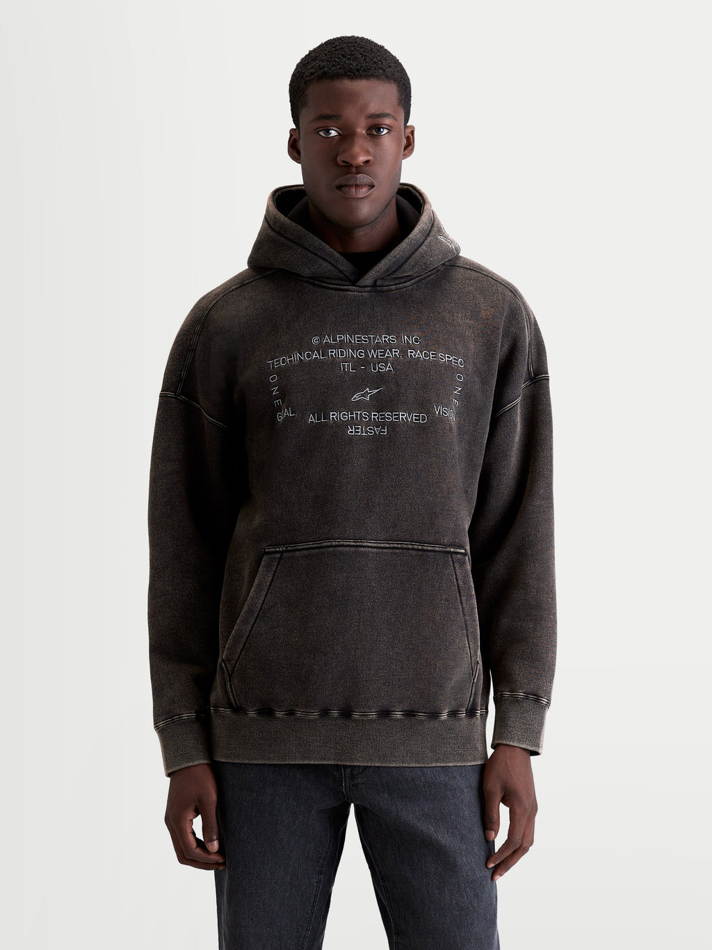 Alpinestars Infinite Washed Oversized Hoodie, Sportswear Pullover for Men and Women, Washed Black, Cotton and Recycled Polyester Fleece, featuring a snow-wash finish, embroidered chest graphic, and kangaroo pocket.