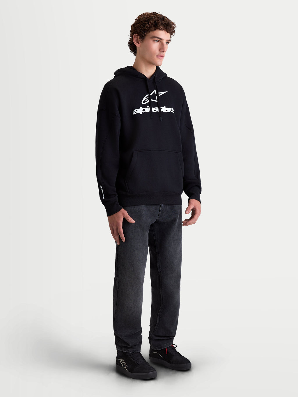 Alpinestars Prelude Oversized Hoodie, Men's Sportswear Fleece Pullover, Black with White puff-print logo, featuring a relaxed oversized fit and kangaroo pocket, shown on a model.
