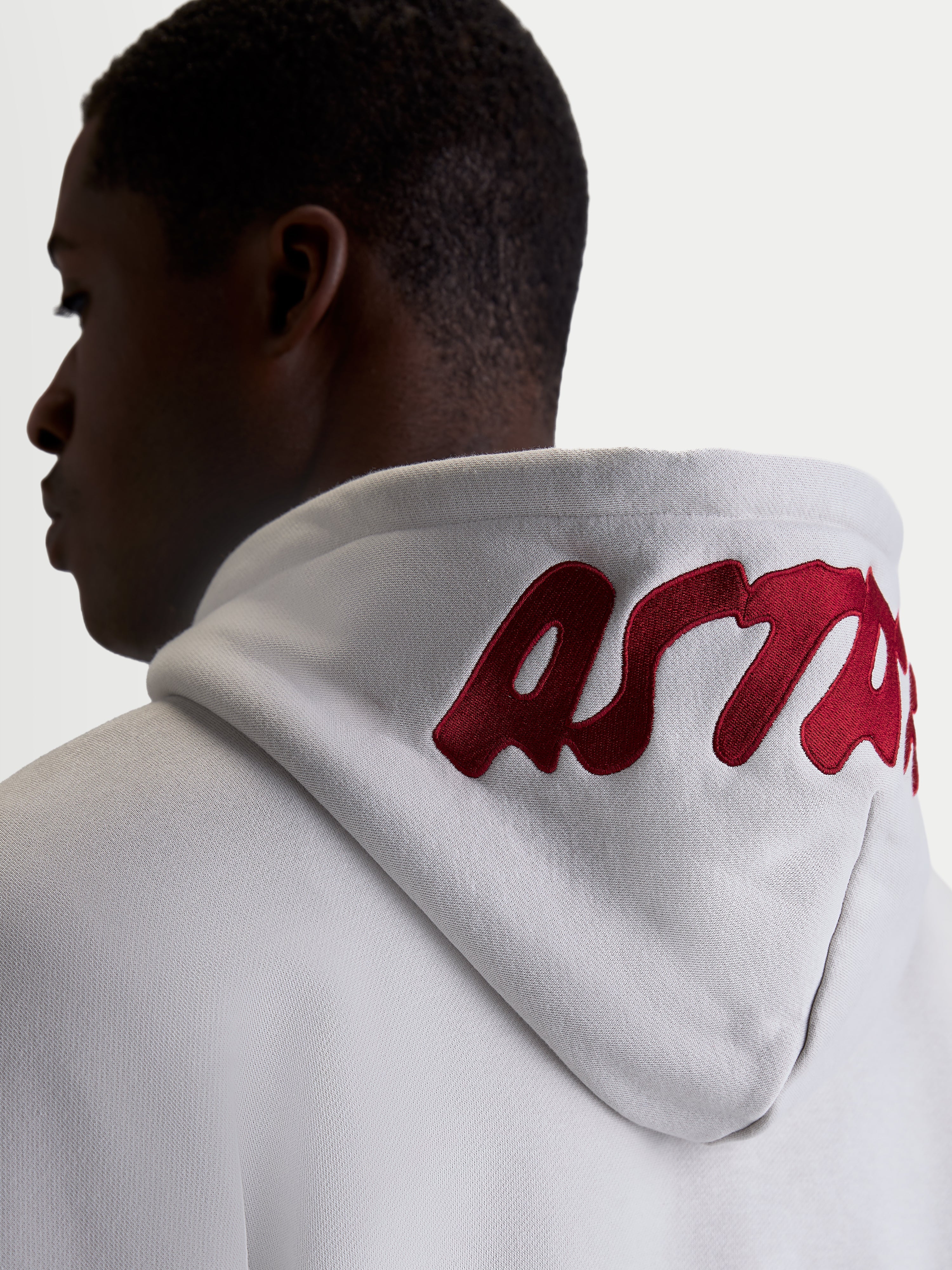 Alpinestars Pioneer Oversized Hoodie, Casual Sportswear Fleece for Men and Women, Cement Gray with Red embroidered logo on the hood, on-model back view highlighting the oversized fit and premium branding.