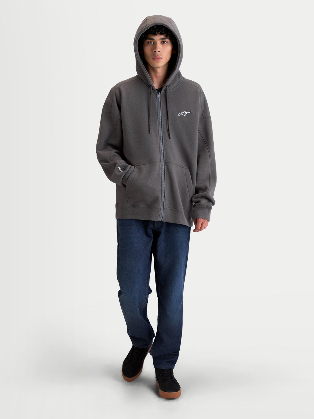 Alpinestars Entity Oversized Hoodie, Premium Motorsport Zip Fleece Sportswear, Charcoal Gray, featuring a Vislon front zipper, self-lined hood with flat drawcords, and kangaroo pocket. On-model view showing the relaxed, oversized silhouette with embroidered Astars logo on the chest and sleeve.