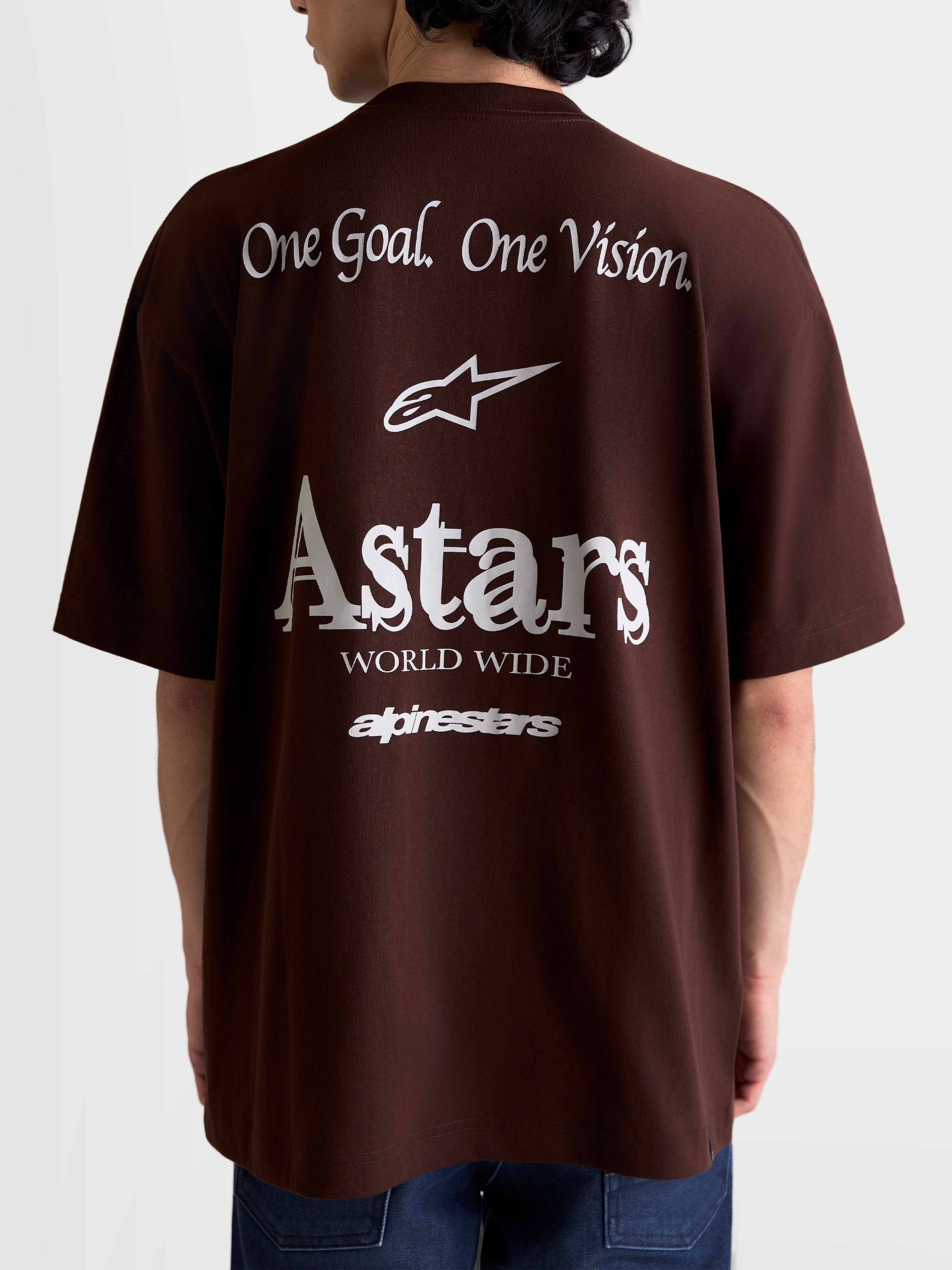 Alpinestars Post Oversized CSF Tee, Short Sleeve Sportswear T-Shirt, Unisex, Brown and White, rear view featuring large white back graphics with 'One Goal. One Vision.' slogan, Astars logo, and 'Astars World Wide' text, relaxed oversized fit, comfortable cotton-poly blend.