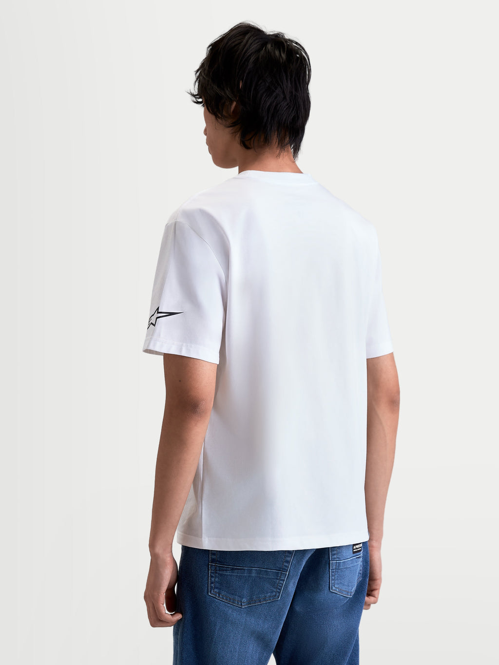 Alpinestars Race Wordmark CSF Tee, Casual Sportswear Short Sleeve T-Shirt, Unisex, White and Black, 60/40 Cotton-Poly Blend, back view on model showing the Alpinestars Ageless logo on the sleeve.