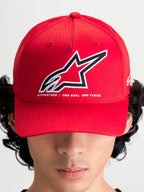 Alpinestars Lineout Hat, Red Sportswear Baseball Cap, on-model front view with a structured crown and curved bill. Features a large embroidered Astars logo in white and black with the brand motto 'ONE GOAL. ONE VISION.' underneath. Casual and performance-inspired red textile headwear for motorsports enthusiasts.