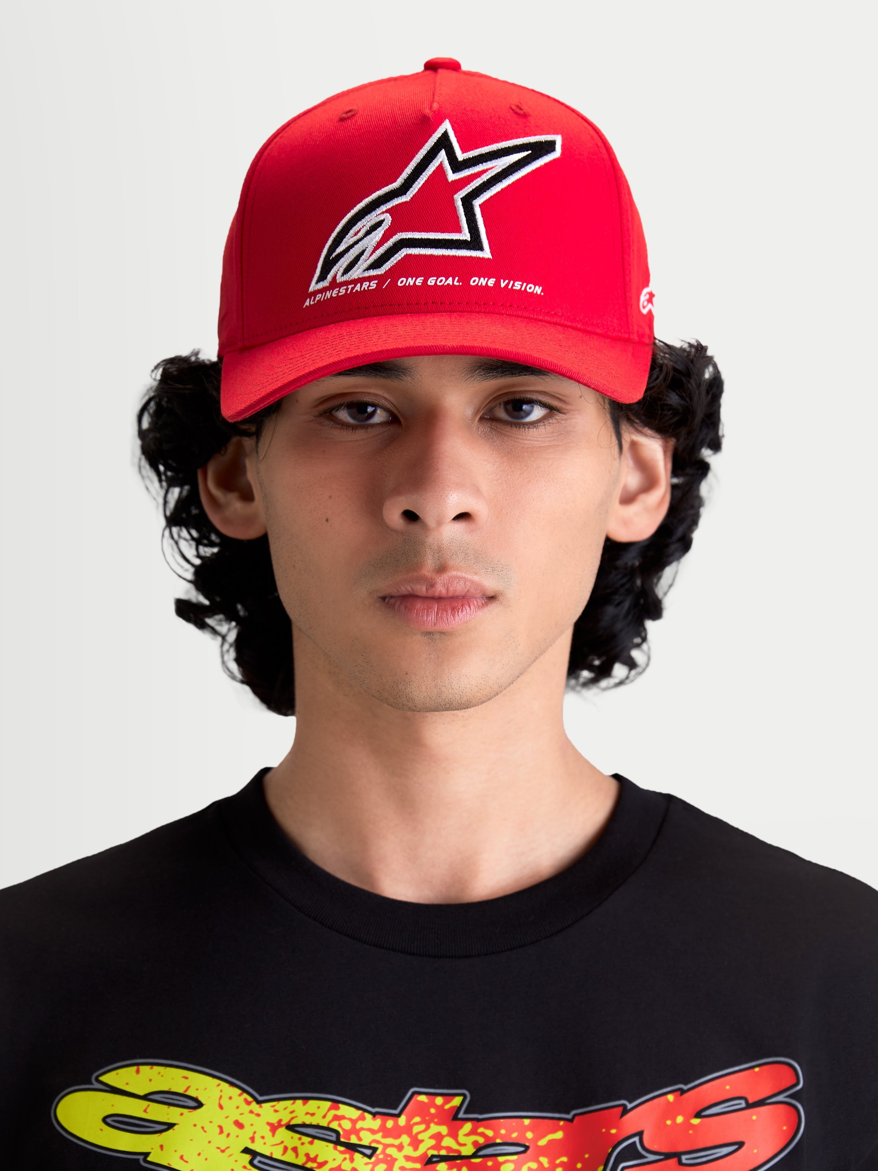Alpinestars Lineout Hat, Red Curved Bill Baseball Cap, Sportswear Headwear for Men and Women, Red and White, featuring a structured crown and embroidered Astars logo with 'One Goal One Vision' slogan. Front view on model.