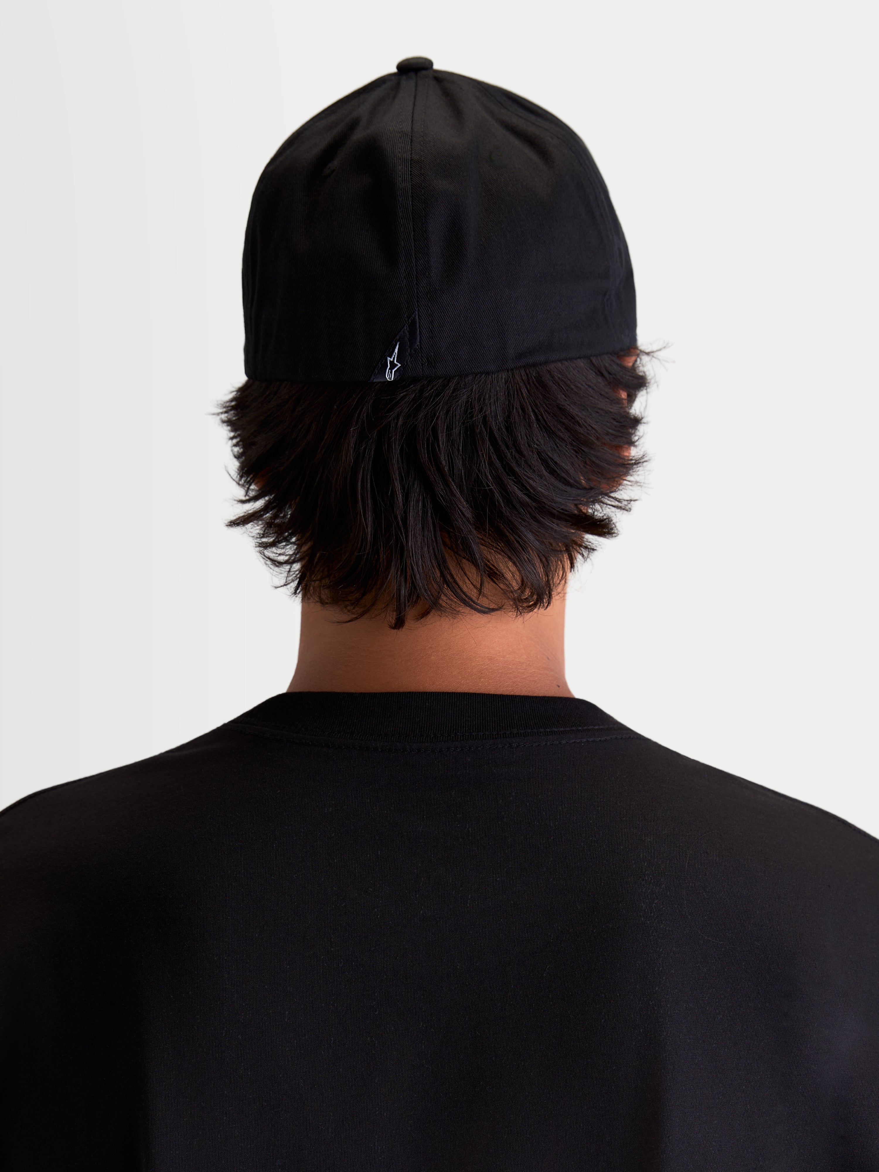 Alpinestars Arclight Hat, Black Sportswear Baseball Cap, Rear View on Model, Featuring a Small White Astars Logo on the Back, Structured Crown and Flex Back Construction, Durable Cotton Twill for Everyday Comfort.