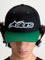 Alpinestars Retro Snapback Hat, Motorsport-inspired sportswear baseball cap with curved bill and structured crown, Unisex, Black and Green, Cotton Twill, front view on model showing the Astars logo with green pop-color running stitch detailing.