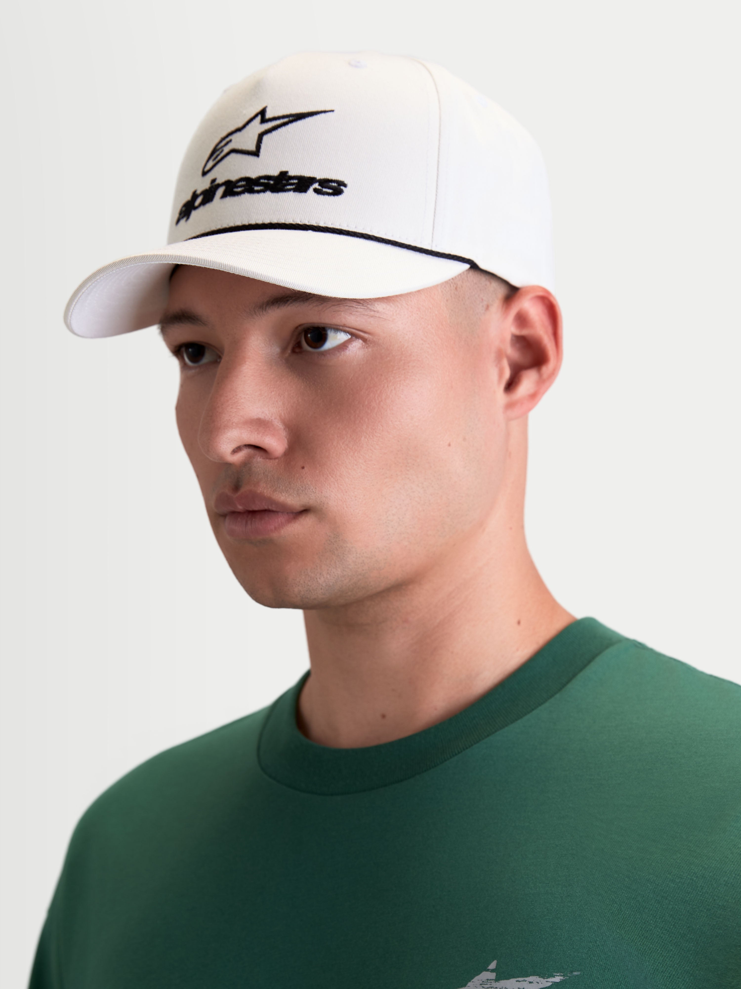 Alpinestars Combo Logo Snapback Hat, Men's Sportswear Baseball Cap, Off White and Black, on-model view featuring front Astars combo logo embroidery, curved bill, and structured crown, 100% cotton twill construction for a premium motorsport look.