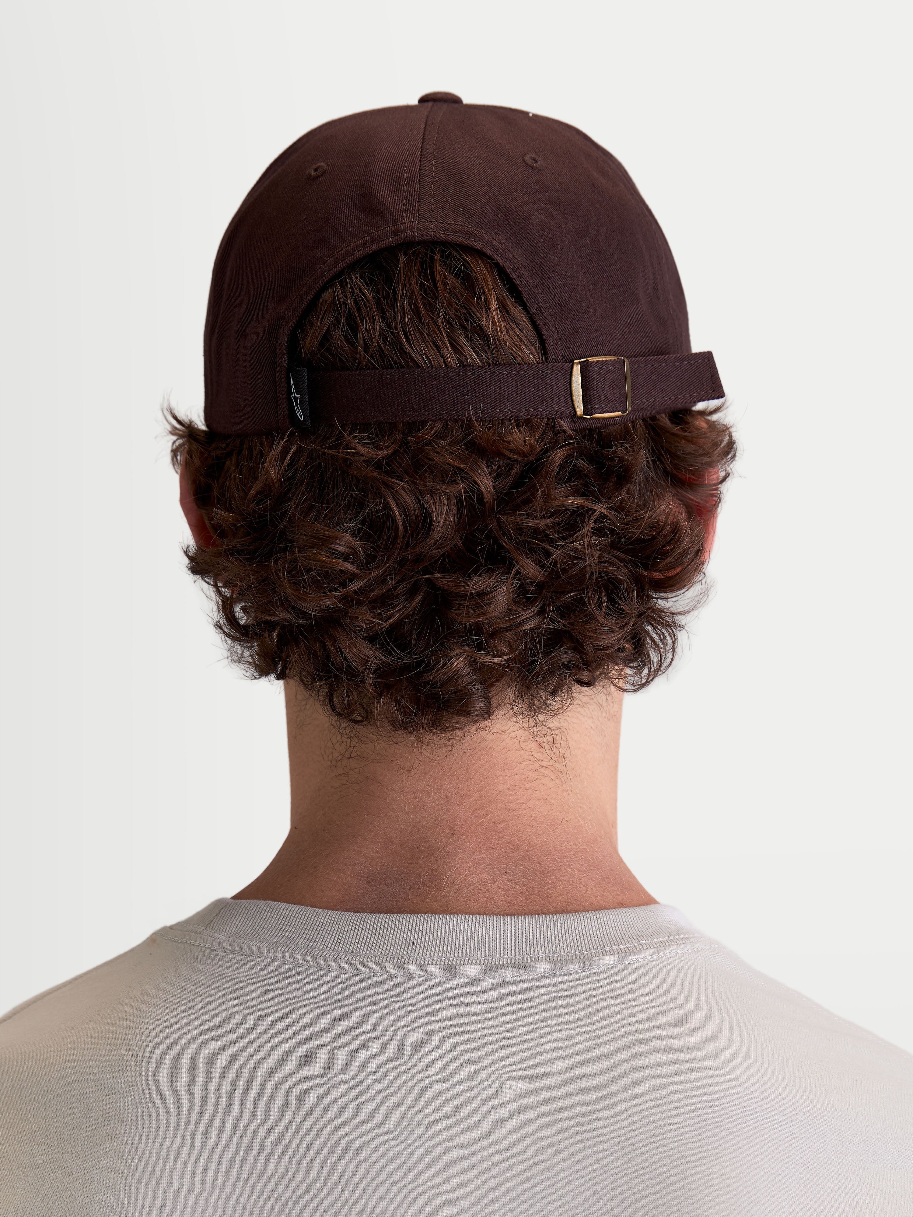 Alpinestars Dylan Dad Hat, Brown Casual Sportswear Cap, 100% Cotton Twill, featuring an adjustable strap-back closure and unstructured low crown, rear view on-model.