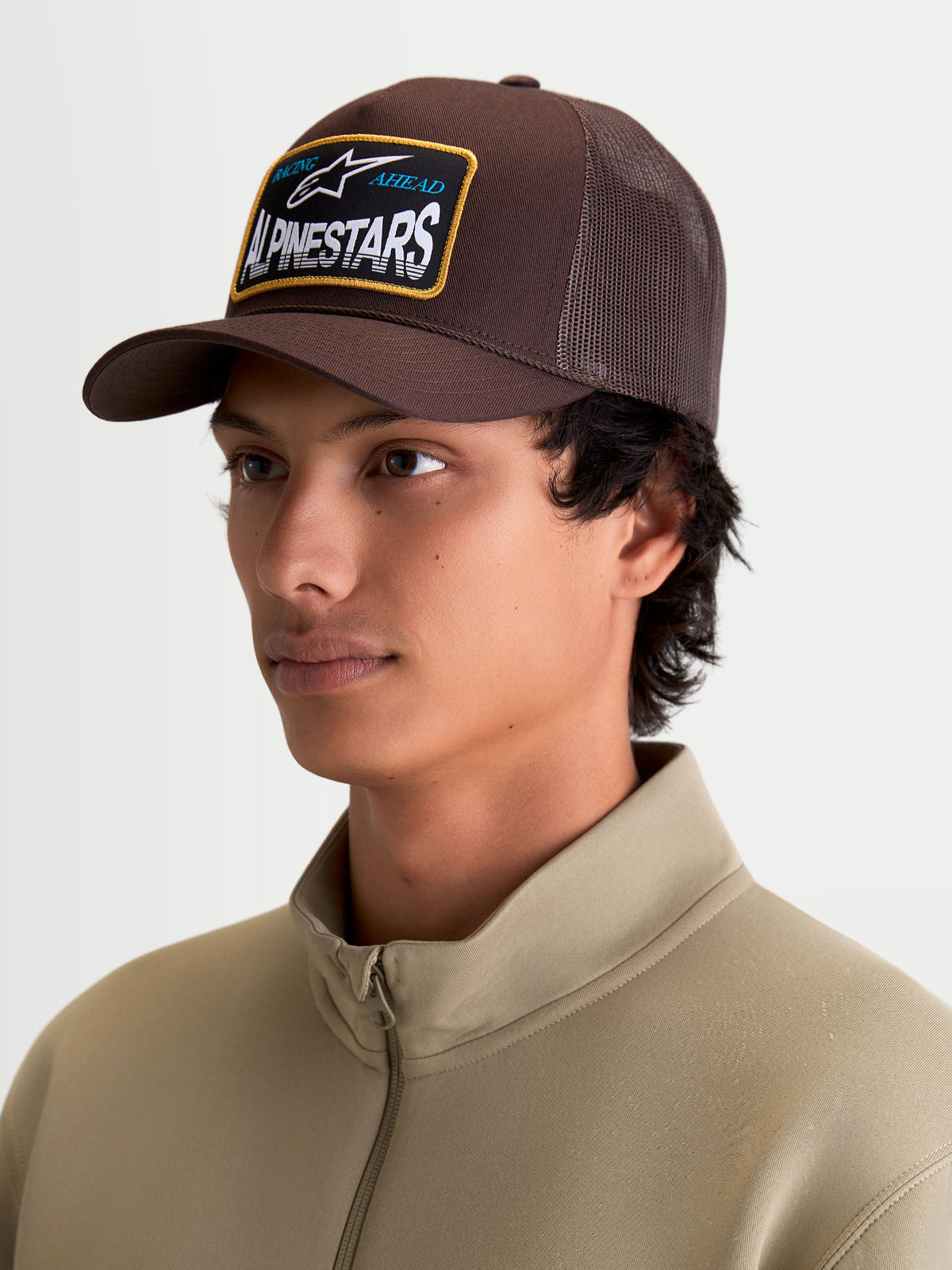 Alpinestars Hemmings Trucker Hat, Casual Sportswear, Unisex, Brown, featuring a cotton twill front and breathable poly mesh back with a premium woven Alpinestars logo patch, on-model.