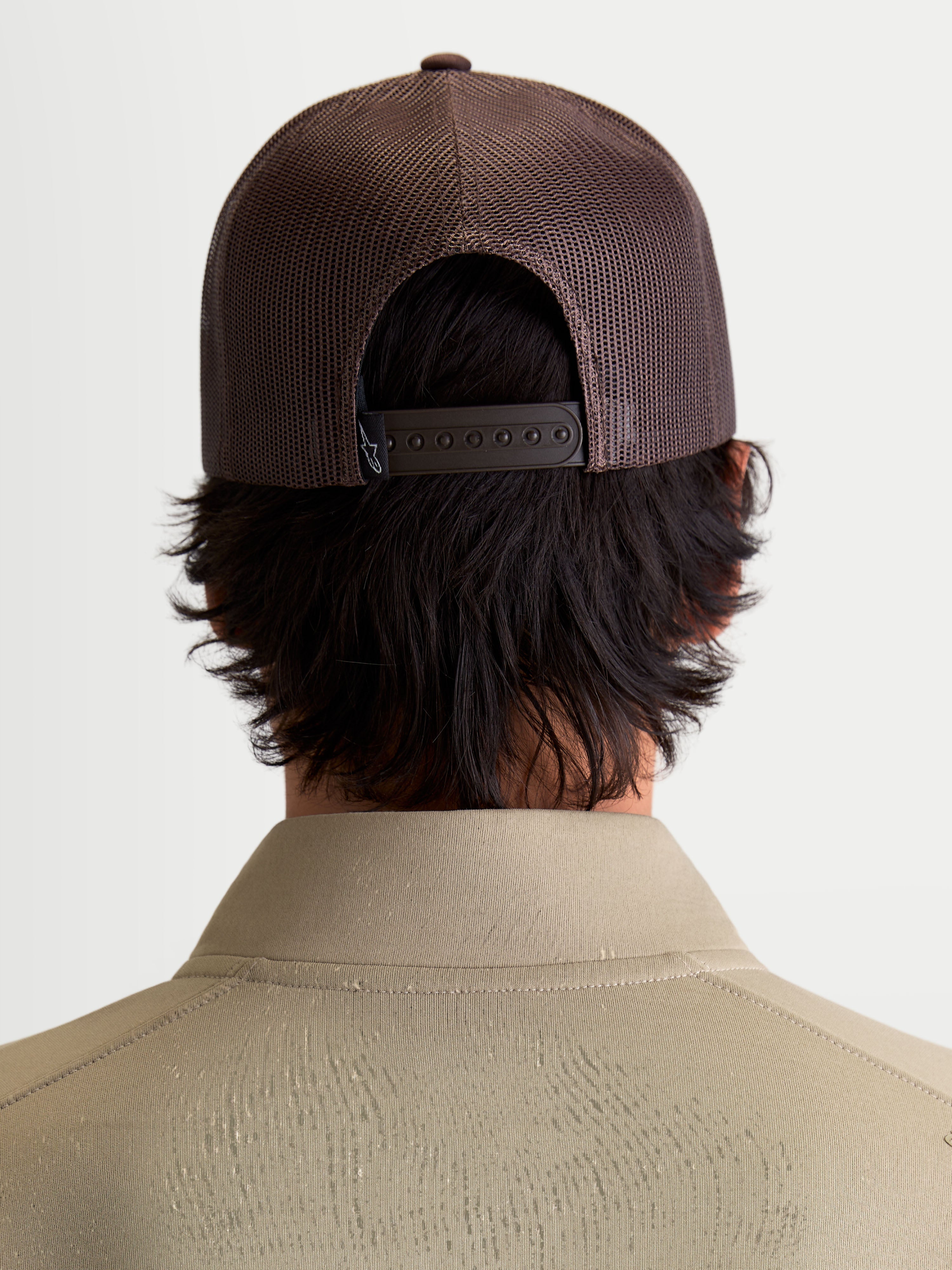 Alpinestars Hemmings Trucker Hat, Brown Sportswear Snapback Cap, Back View on Model showing Breathable Poly Mesh Panels and Adjustable Snap Closure for Casual Everyday Wear