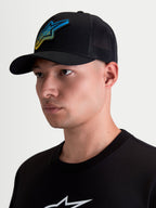 Alpinestars Meteorite Trucker Hat, Sportswear Casual Lifestyle Mesh Back Cap, Men's, Black, featuring a blue and yellow Astars gravel texture woven logo patch, curved bill, and structured crown, shown on model.