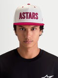 Alpinestars Stadium Snapback Hat, Casual Sportswear Cap for Men, Off White and Red, on-model front view showing the flat bill, structured crown, and large red ASTARS logo applique with contrast running stitch.