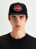 Alpinestars Hotlink Trucker Hat, motorsport-inspired sportswear cap in black, featuring a flat bill, structured crown, and a red and white Astars woven patch with a bike chain border on the front, worn by a model.