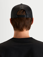 Alpinestars Hotlink Trucker Hat, motorsport-inspired sportswear cap, unisex, Black, rear view showing snapback closure and mesh construction worn by a model