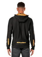Alpinestars Sessions V3 Hoodie, back view, black with gold branding, gold 'alpinestars' wordmark on the lower back and 'astars' on the forearms, gold mesh-lined hood, casual motorsport-inspired streetwear