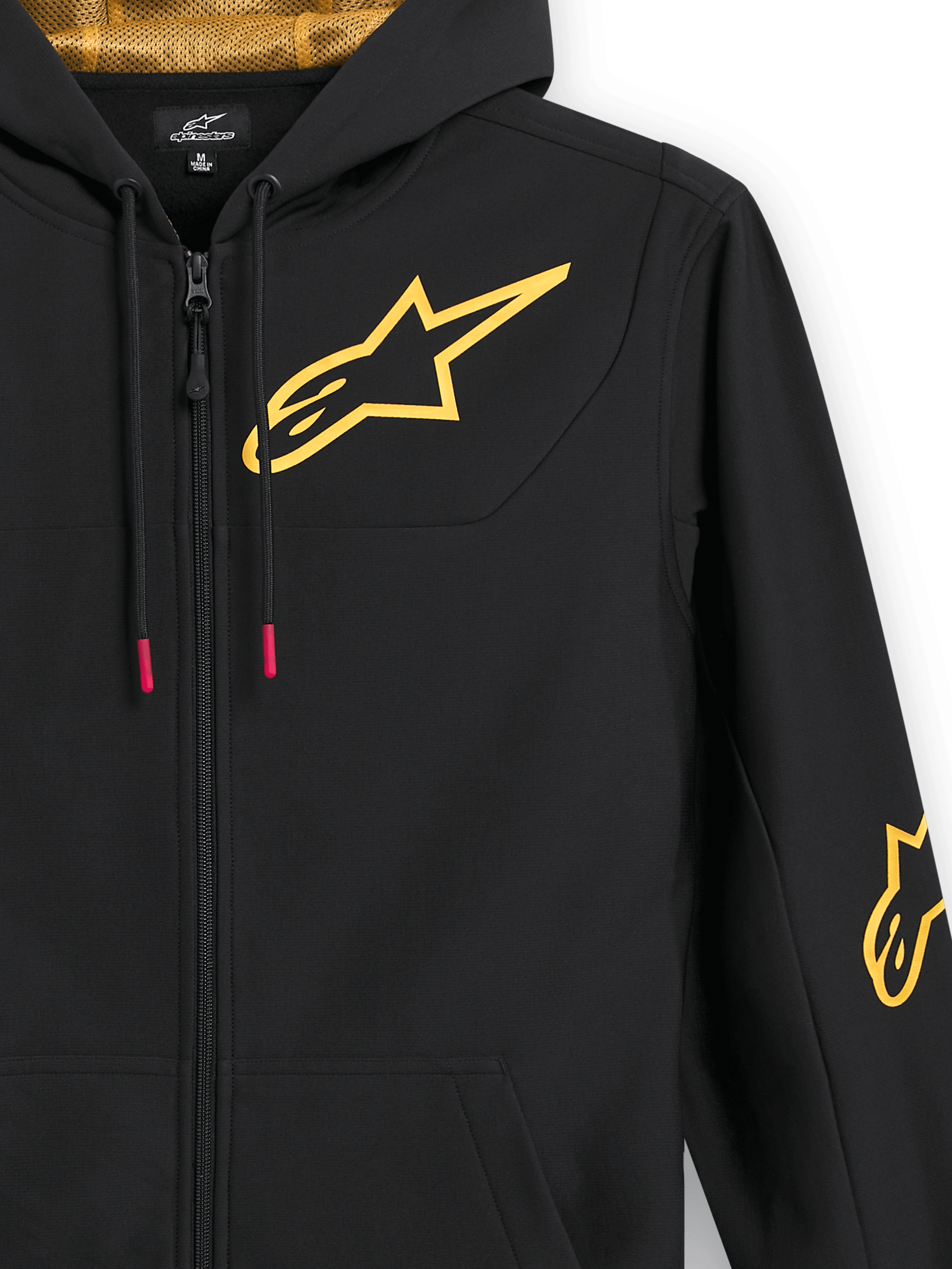 Alpinestars Sessions V3 Hoodie, black zip-up fleece, close-up showing large gold chest logo, gold mesh-lined hood, tech drawcords with red accents, casual motorsport-inspired streetwear