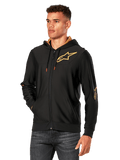 Alpinestars Sessions V3 Hoodie, Black with Gold logos, zip-up fleece hoodie worn by a model with dark jeans, featuring a gold mesh-lined hood and red-tipped drawcords, casual motorsport-inspired streetwear