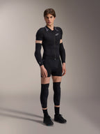 Alpinestars A-Motion Plasma Protection Boxers, Black, worn as part of a complete mountain bike protective base layer including a short-sleeve padded jacket, elbow guards, and knee guards, sleek athletic design for off-road performance