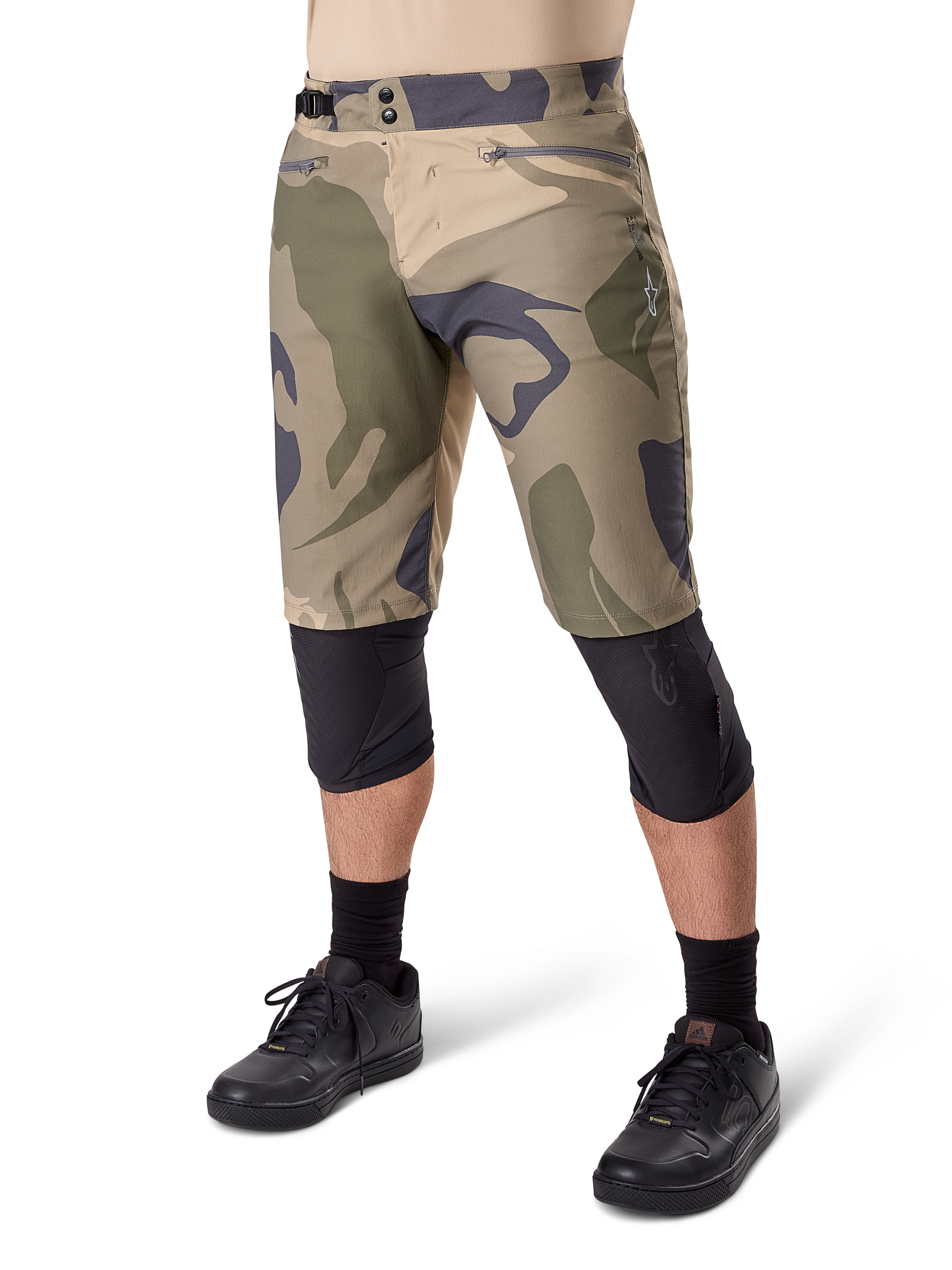 Alpinestars A-Dura Camo Liner Short, Mountain Bike Shorts, Brown Camo pattern, front view showing zippered pockets and side waist adjusters, worn with black knee pads and black cycling shoes, durable gear for MTB