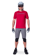 Alpinestars A-Aria Elite Shorts, Men's MTB Cycling Shorts in Dark Gray, with flexible stretch fabric and a red racing jersey.