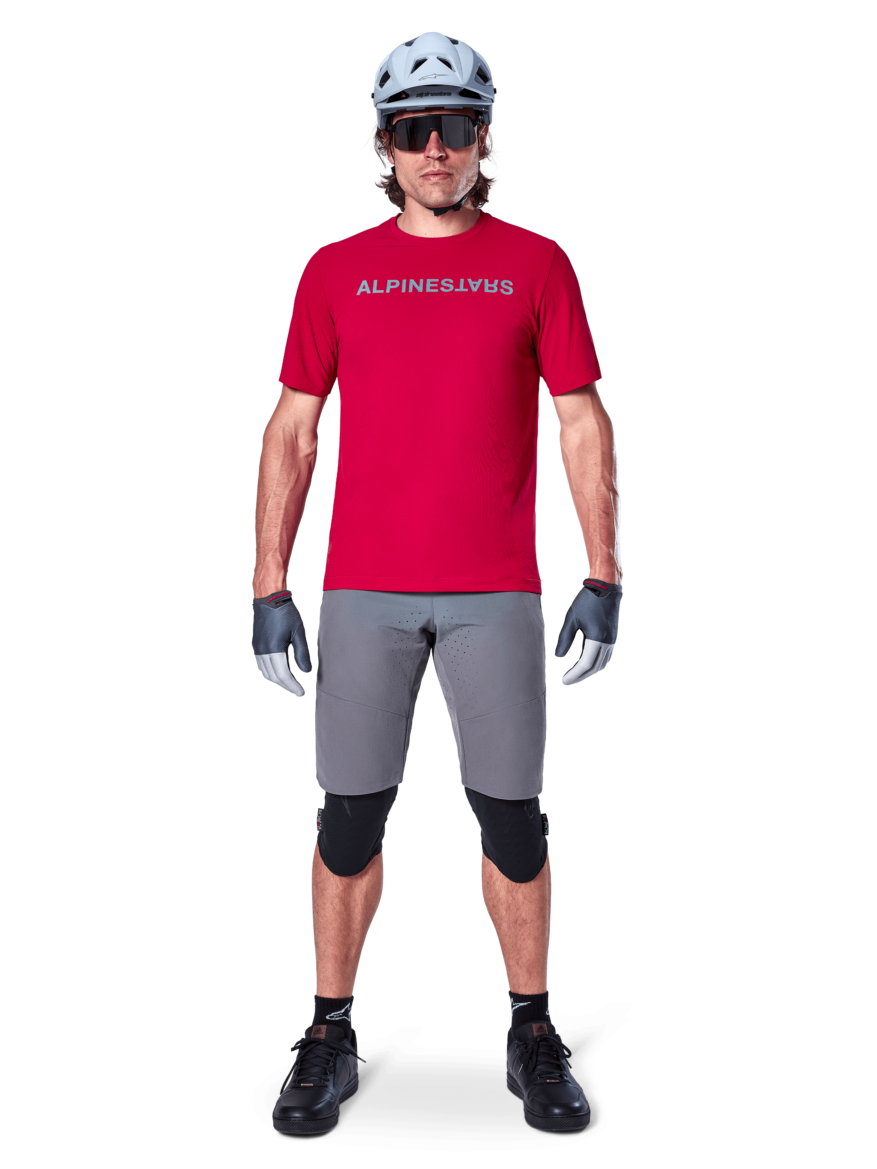 Alpinestars A-Aria Elite Shorts, Men's MTB Cycling Shorts in Dark Gray, with flexible stretch fabric and a red racing jersey.