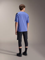 Alpinestars A-Aria Lite Short, Black mountain bike shorts, paired with a blue A-Aria Polartec Elite short-sleeve jersey and black knee pads, back view of a rider in performance cycling gear for off-road trails.