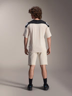 Alpinestars A-Aria Elite Shorts and A-Aria Polartec Elite SS Jersey, Ecru with black shoulder panels, rear view of a model in mountain bike performance gear, styled with black socks and shoes