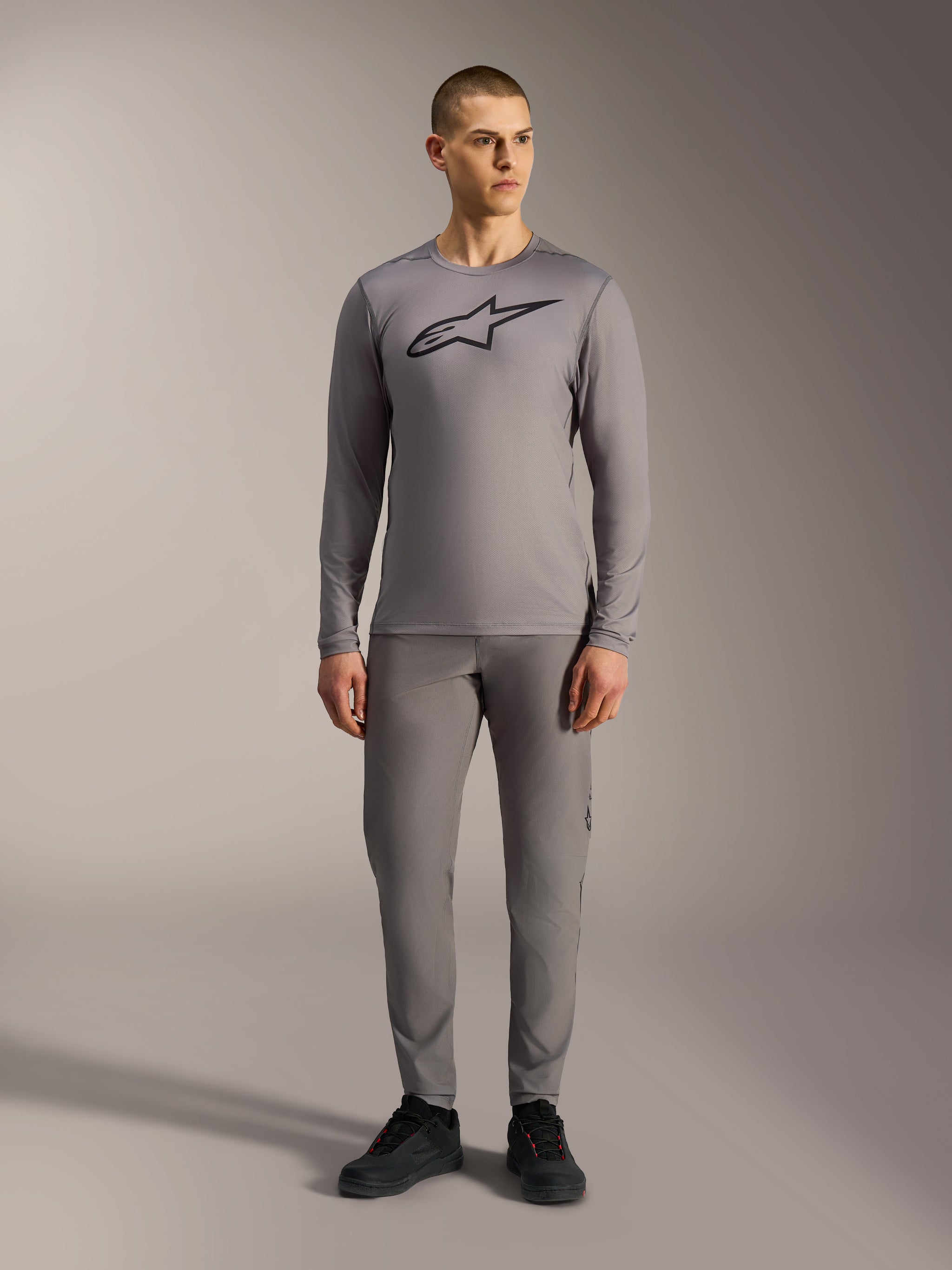 Alpinestars A-Dura Ride Long Sleeve Jersey in Gray, featuring a large black chest logo, worn with matching MTB pants.