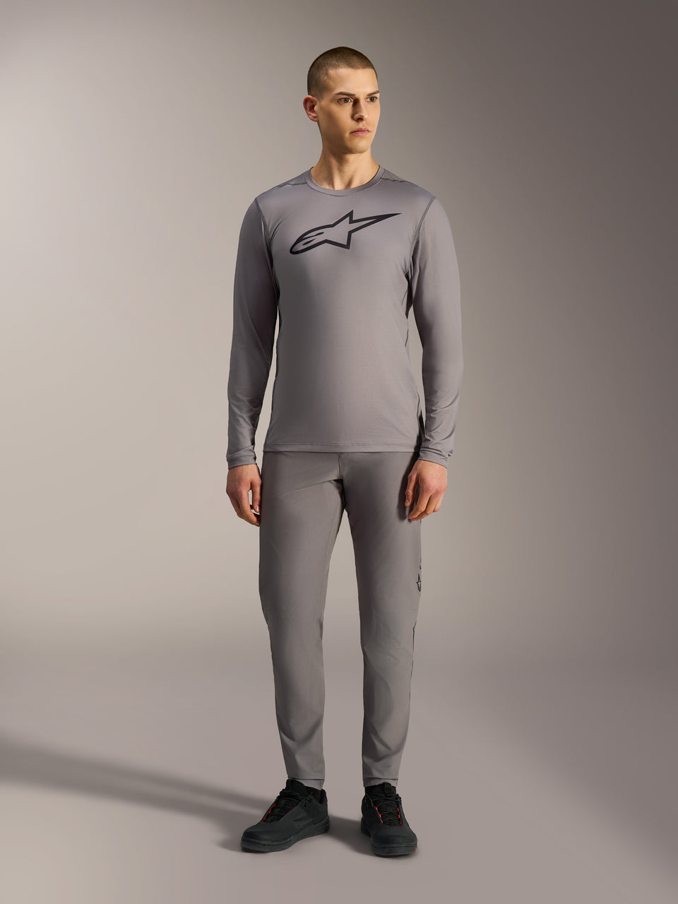 Alpinestars A-Dura Ride Long Sleeve Jersey in Gray, featuring a large black chest logo, worn with matching MTB pants.