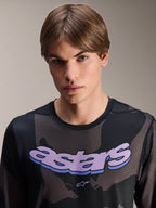 Alpinestars A-Dura Hollow Camo Jersey - Long Sleeve, Black Camo with purple 'astars' chest graphic, studio shot of male model wearing MTB apparel, casual and technical mountain bike style