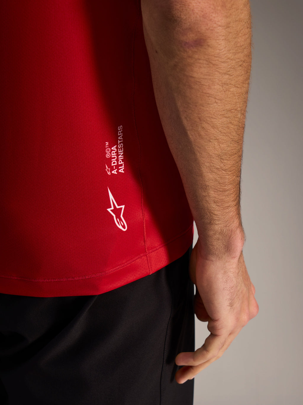 Red A-Dura ASTARS Jersey 2.0 close-up featuring white branding and breathable jacquard fabric for mountain biking.