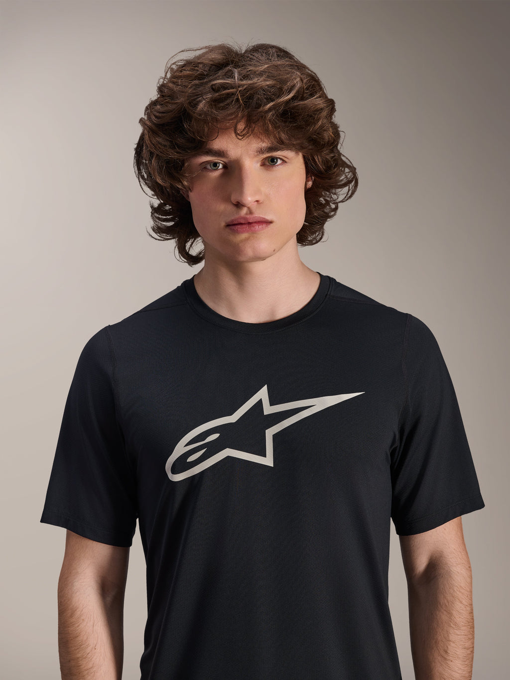 Alpinestars A-Dura Astar Short Sleeve Jersey, Black, featuring a large white Astar logo on the chest, worn by a male model, casual mountain bike performance apparel