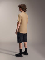 Alpinestars A-Dura Shorts, Mountain Bike Shorts, Black, paired with a tan A-Dura short-sleeve jersey and black riding shoes, featuring a regular fit and durable construction for off-road cycling, rear-side view