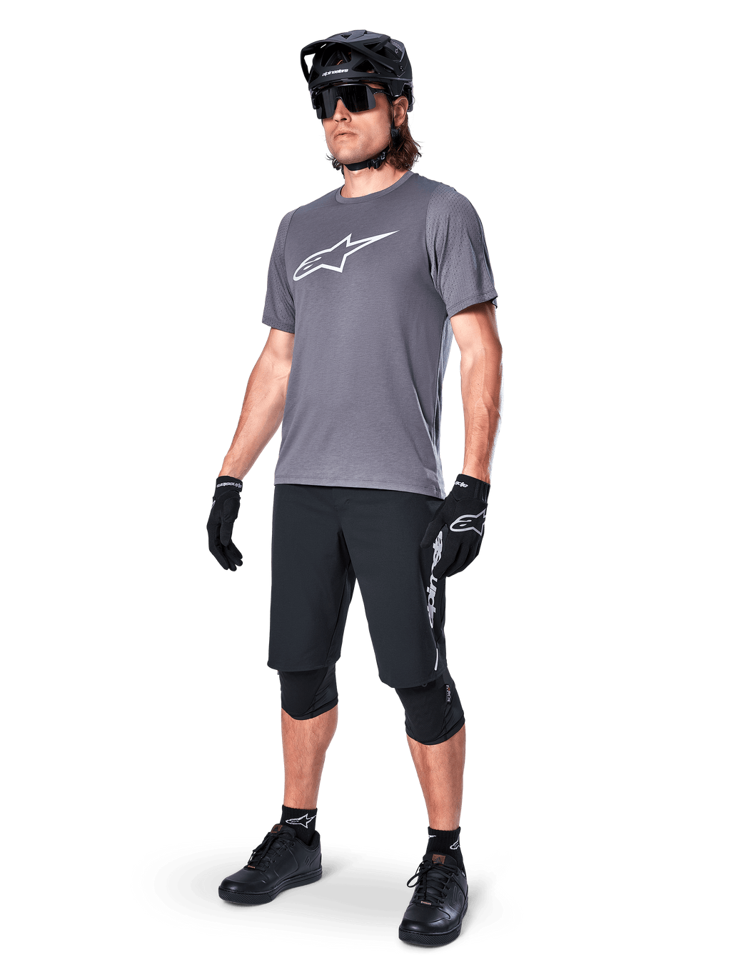 Alpinestars A-Dura Dri Astar Short Sleeve Jersey, Dark Gray, white Astars logo on chest, worn by model with black mountain bike shorts, helmet, sunglasses, and gloves, complete off-road cycling gear