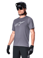 Alpinestars A-Dura Dri Astar Short Sleeve Jersey, Dark Gray, white chest logo and mesh sleeve panels, worn with black MTB helmet, sunglasses, and gloves, performance mountain biking apparel