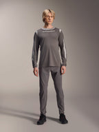 Alpinestars A-Dura Dri Wool Long Sleeve Jersey, Dark Gray, worn by model with matching gray pants and black shoes, white Alpinestars branding on chest, light gray mesh panels on shoulders and sleeves, technical mountain bike gear